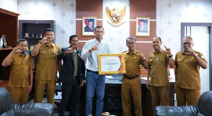 Ketua Komisi Informasi Aceh, Junaidi, menyerahkan Penghargaan, diterima langsung oleh Sekretaris DPRA, Khudri, S.Ag., MA, yang didampingi oleh para Kepala Bagian, Kepala Subbagian, serta jajaran staf Pejabat Pengelola Informasi dan Dokumentasi (PPID) Sekretariat DPRA, dalam pertemuan yang berlangsung di Ruang Kerja Sekretaris Dewan, Gedung Sekretariat DPRA Banda Aceh, Selasa (20/01/2026).